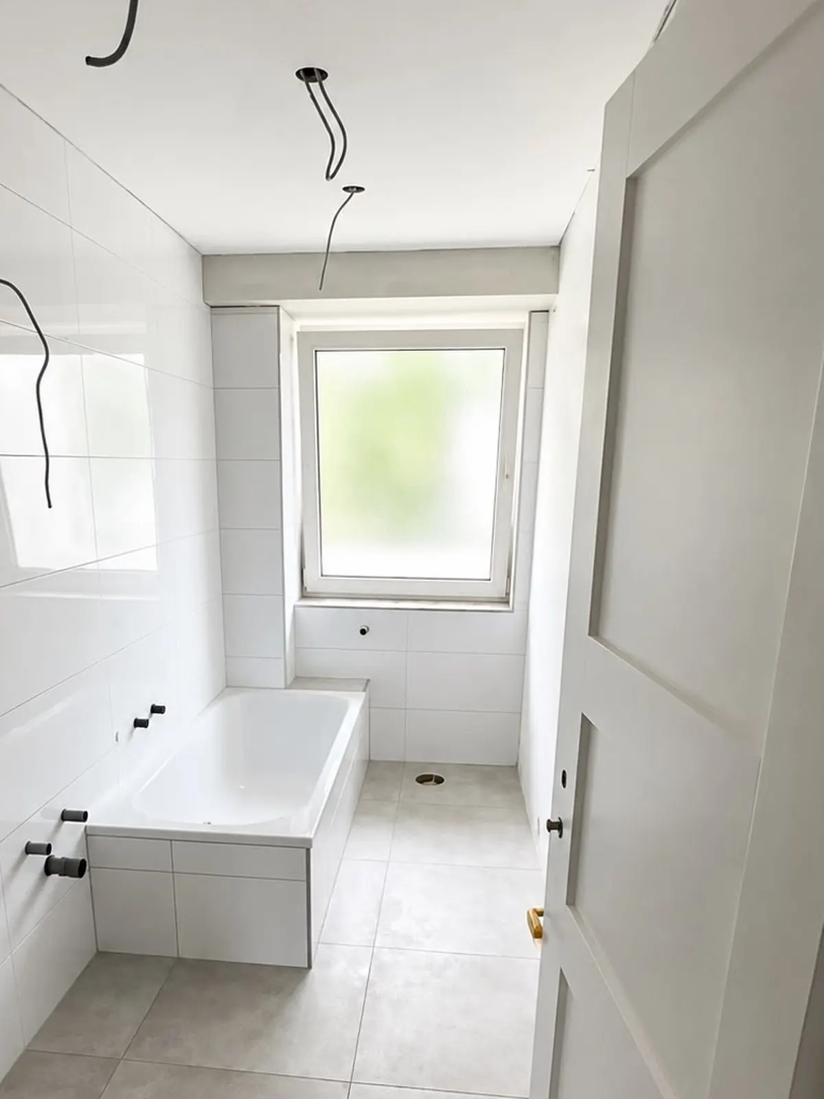 Fertig verputztes und gefliestes Badezimmer nach der Sanierung durch COLORD Meisterbetrieb